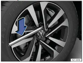 Volkswagen ID.3. Fig. 1 Removing wheel bolts with the lug wrench.